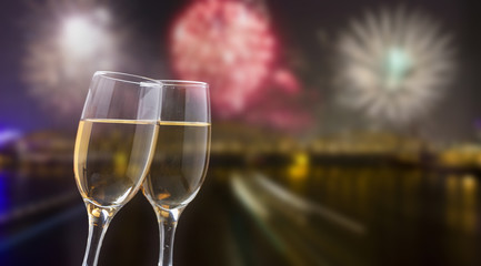 Glasses with champagne against fireworks and city lights