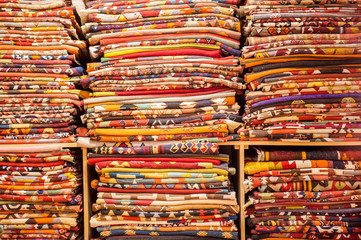 A large selction of blankets and their patterns on a shelf