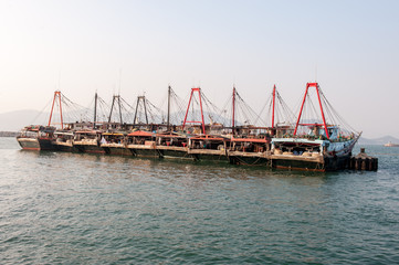 Row of large Chinese fishing boats on water