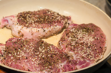 Cooking meat with spice in a frying pan. Selective focus