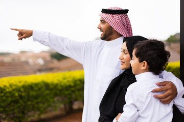 muslim family outside their home pointing