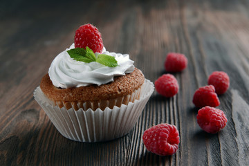 Delicious cupcake with berries and fresh mint on wooden table close up