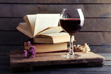 Beautiful composition with glass of wine with old books on table close up