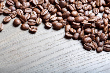 Coffee beans on the brown wooden background.