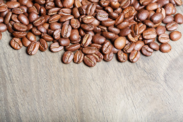 Fresh coffee beans on wood, ready to brew delicious coffee.