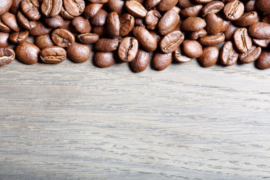 Coffee beans on wood background.