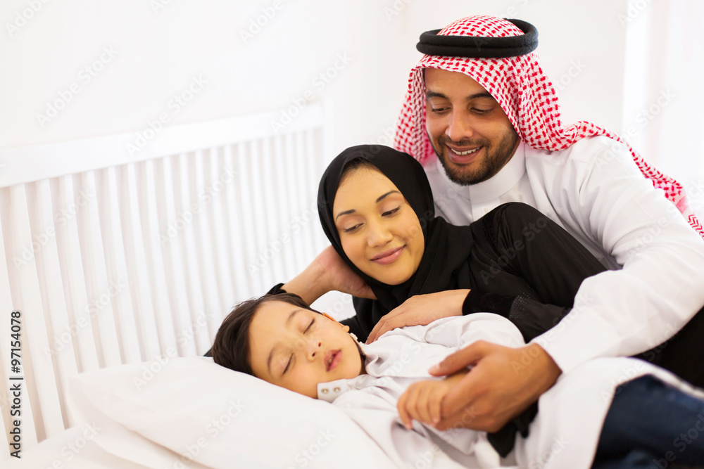 Wall mural muslim parents with their baby relaxing in bed