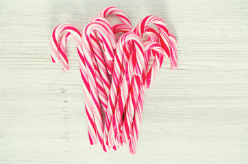 Striped Christmas candies on wooden surface