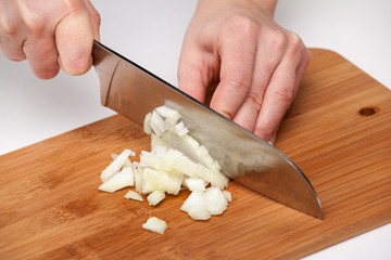 Cutting the vegetables with a kitchen knife on the board