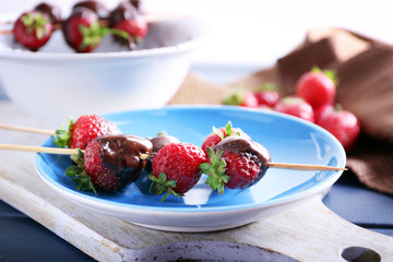 Delicious strawberries in chocolate on kitchen table