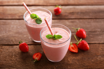 Fresh strawberry yogurt with berries around on wooden background