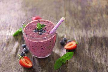 Fresh blueberry yogurt with mint and berries on wooden background