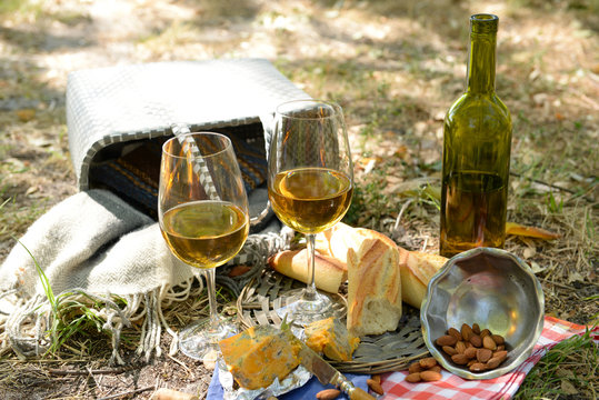 Beautiful composition of wine, cheese, almonds and baguette, outdoors