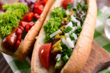 Hot dogs and vegetables on wooden cutting board