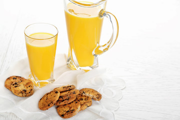 Tasty cookies with chocolate crumbs and orange juice on white table