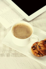 Cup of coffee and tasty cookies with chocolate crumbs on grey checkered napkin, close up