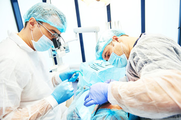 dentist in uniform perform operation at dentistry office