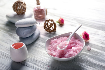 Composition of flowers, salt and stones on white wooden background, in spa salon