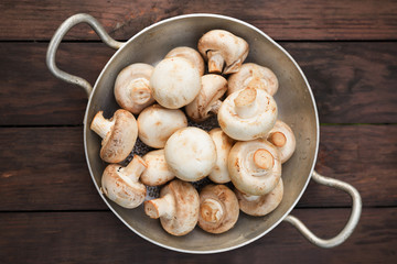 champignons portobello mushrooms in pan on a wooden background