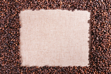 Frame of roasted coffee beans on the linen fabric