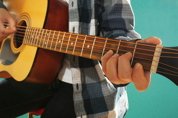 Fototapeta na wymiar Musician plays guitar on blue background, close up
