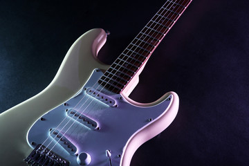Fototapeta na wymiar Part of electric guitar, on dark lighted background