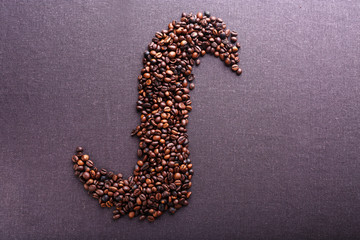 Roasted coffee beans on grey textile background