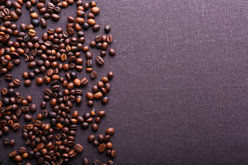 Roasted coffee beans on grey textile background