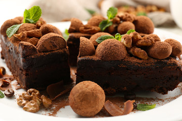 A piece of chocolate cake with walnut and mint on the table, close-up