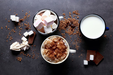 Cup of coffee and sweets on black wooden background
