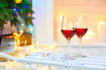 Two red wine glasses near fireplace, Christmas atmosphere