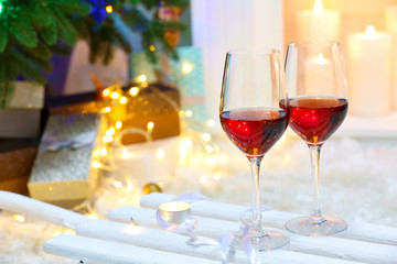 Two red wine glasses near fireplace, Christmas atmosphere