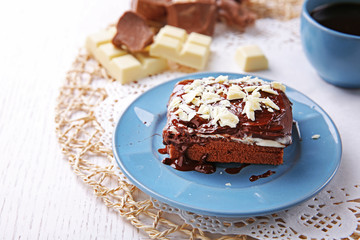 Delicious chocolate brownie on plate on wooden background