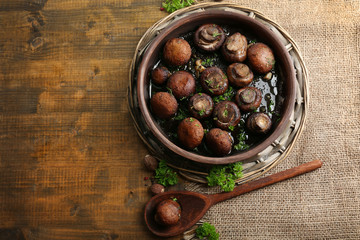 Obraz premium Baked champignons mushrooms with butter, parsley and roasted garlic in brown bowl