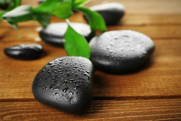 Spa stones and bamboo branch on wooden background