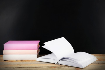 Fototapeta premium Books on a table on blackboard background