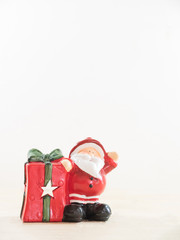 Santa claus with his gift present box on wooden table white back