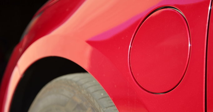 Close up of an Electric Vehicle's charge port as it's unplugged, and the car is driven away