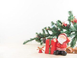 Santa claus with his gift present box and christmas tree on wood