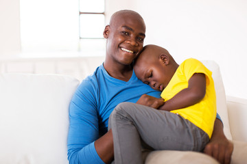 father sitting on the couch with his son