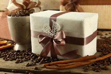 Beautiful gifts with bows and coffee grains on wooden background