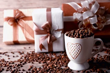 Plexiglas foto achterwand Beautiful gift with bow and coffee grains in mug, on wooden background © Africa Studio