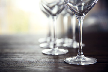 Empty wine glasses on wooden table against blurred background