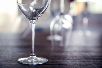 Empty wine glasses on wooden table against blurred background