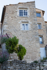Fototapeta na wymiar Ancient building with blue shutters in Provence, France