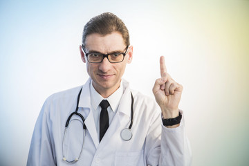 doctor standing with stethoscope shows the gesture of attention