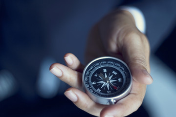 Businessman with a compass holding in hand, color tone film look - Powered by Adobe