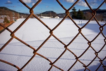 metal fence with rust in front of snow
