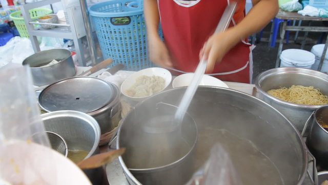 Noodle shop cooking noodle on street side.