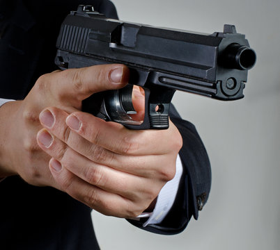 man in suit holding gun